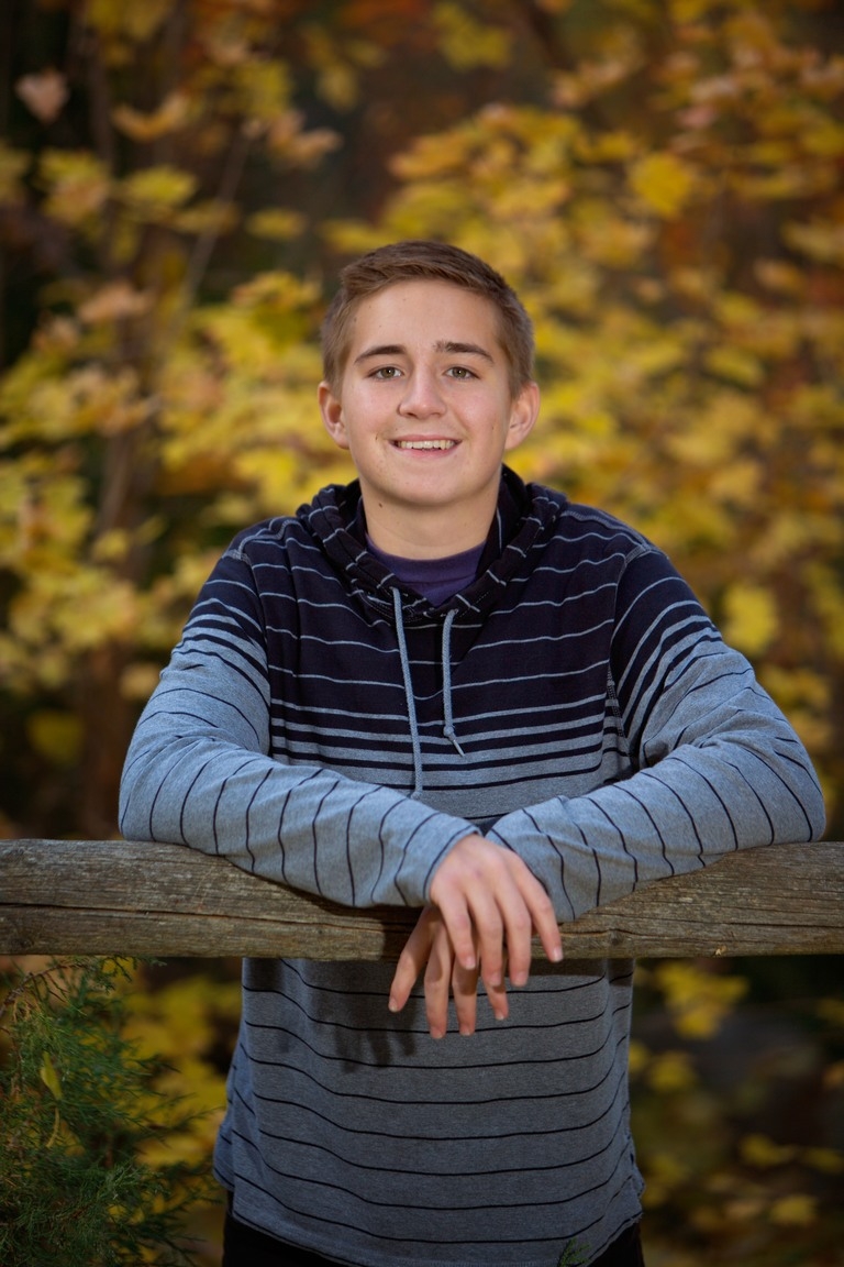 Senior portrait of a student in a striped hoodie outdoors