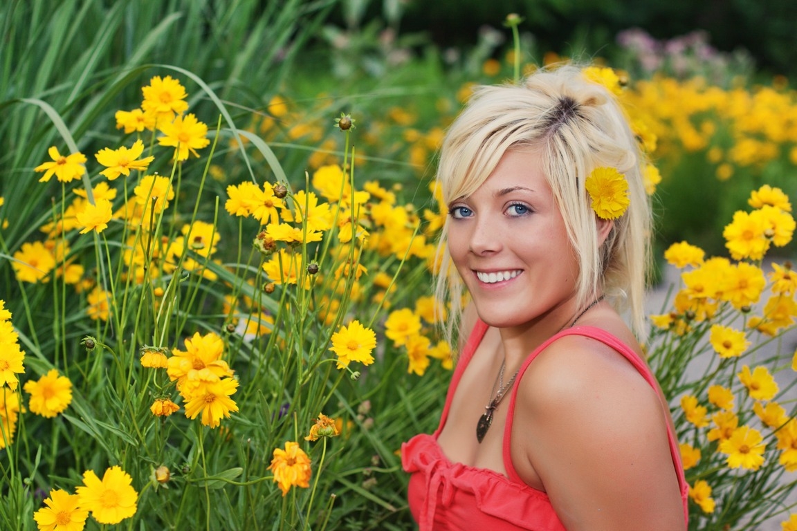 Senior in a red top surrounded by yellow flowers