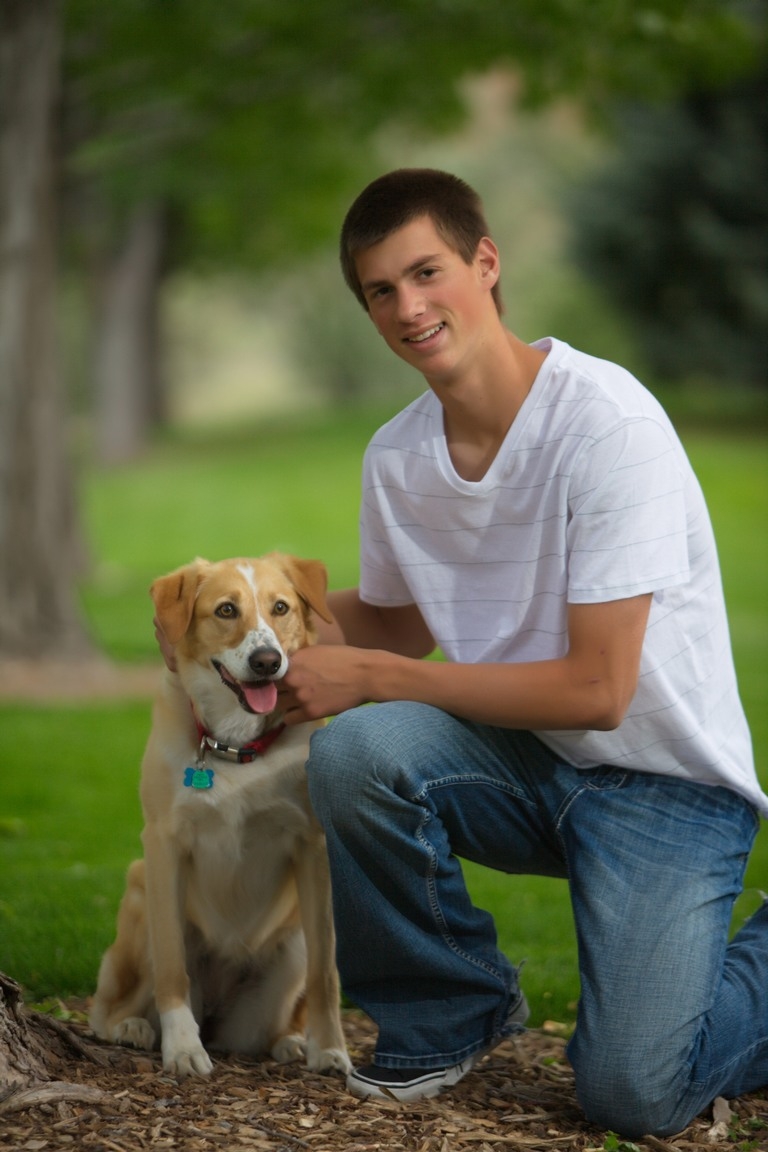 Senior portrait of a student with a dog outdoors