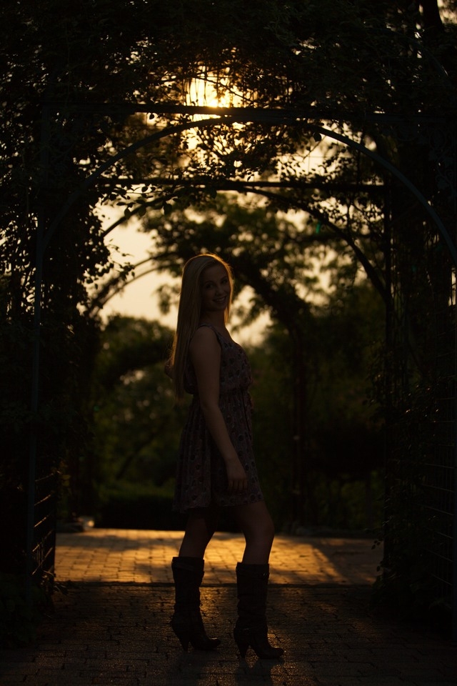 Silhouette senior portrait beside a tree at sunset