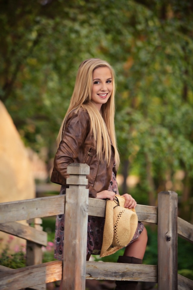 Senior in a brown jacket seated on a bench